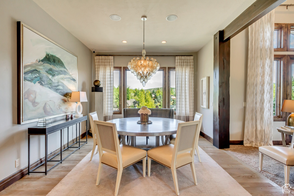 Dining area with baseboards, recessed lighting, light wood-style flooring, and a notable chandelier