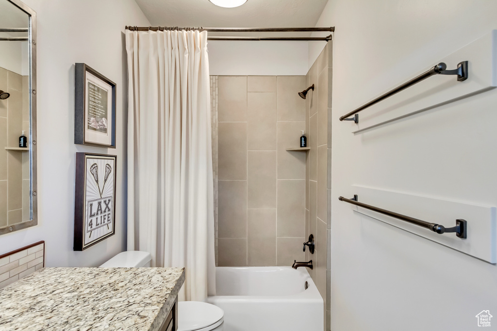 Full bath featuring toilet, shower / bathtub combination with curtain, and vanity