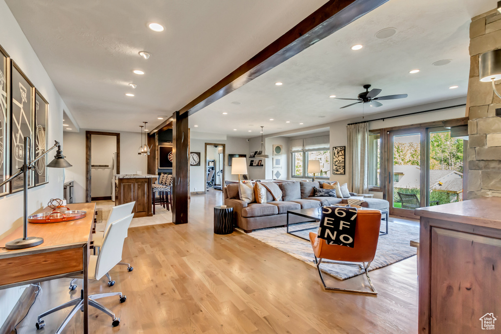 Living room featuring a barn door, a ceiling fan, recessed lighting, and light wood-style flooring