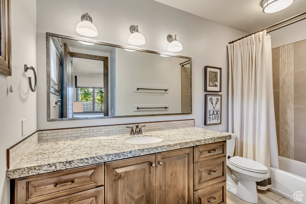 Full bathroom with backsplash, toilet, shower / bathtub combination with curtain, and vanity