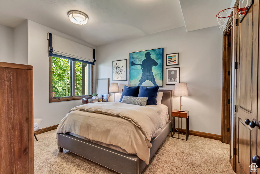 Bedroom with light colored carpet and baseboards
