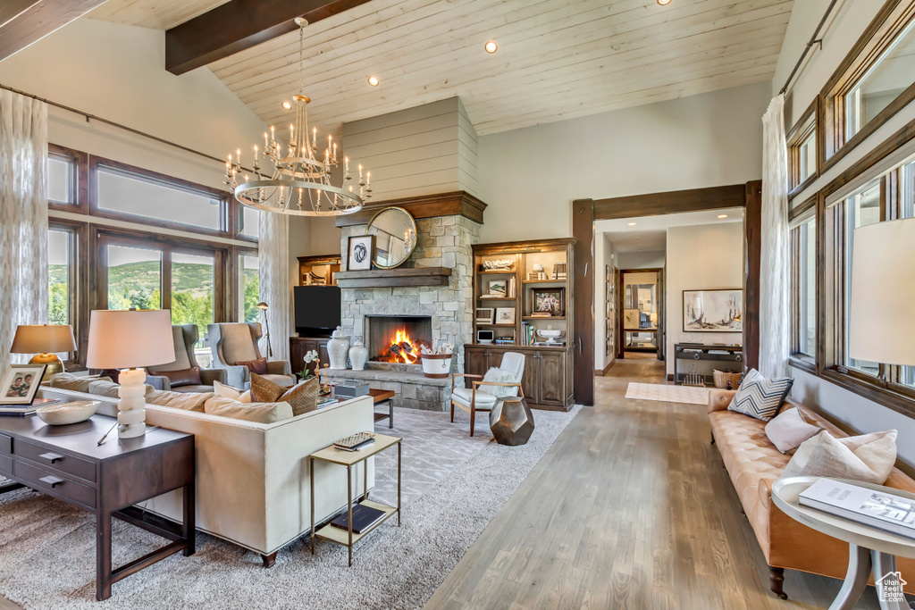 Living area featuring wood ceiling, high vaulted ceiling, an inviting chandelier, and wood finished floors
