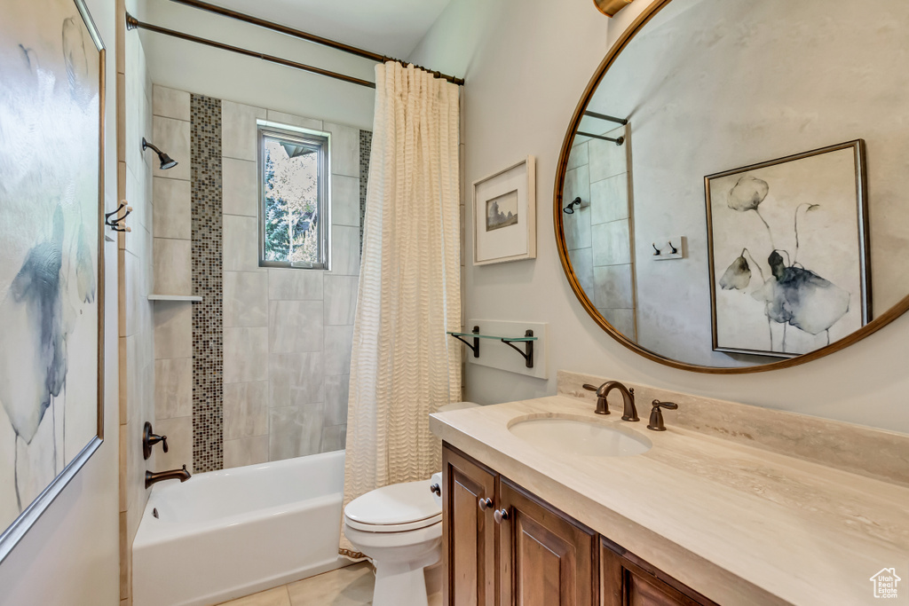 Bathroom with vanity, shower / tub combo, and toilet