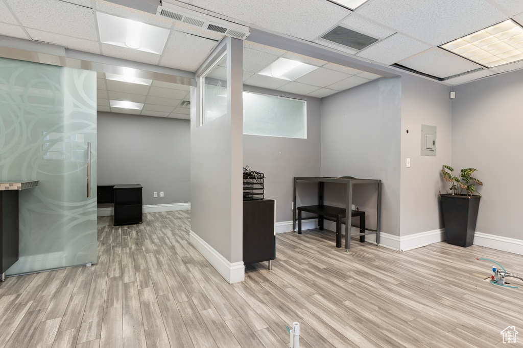 Interior space featuring a paneled ceiling, baseboards, visible vents, and light wood-type flooring