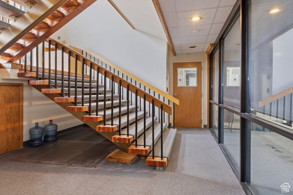 Stairs with carpet flooring and recessed lighting