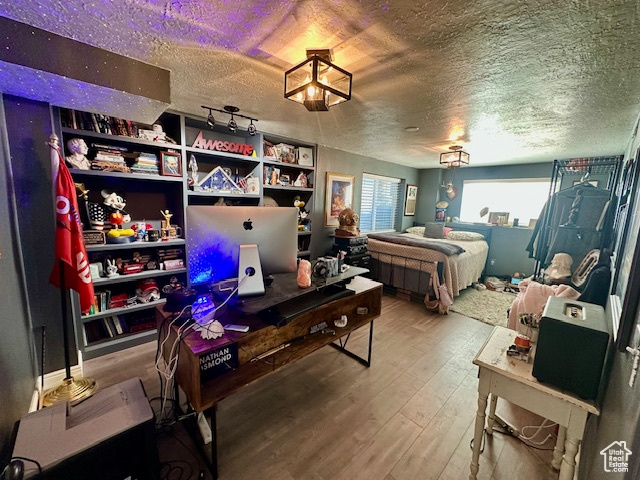 Bedroom featuring a textured ceiling and hardwood / wood-style flooring