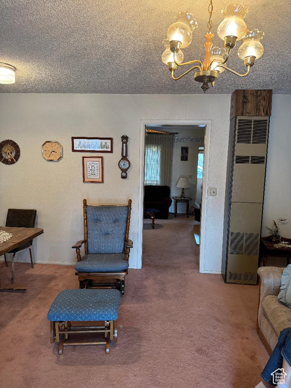 Sitting room with a chandelier, a textured ceiling, carpet floors, and a heating unit