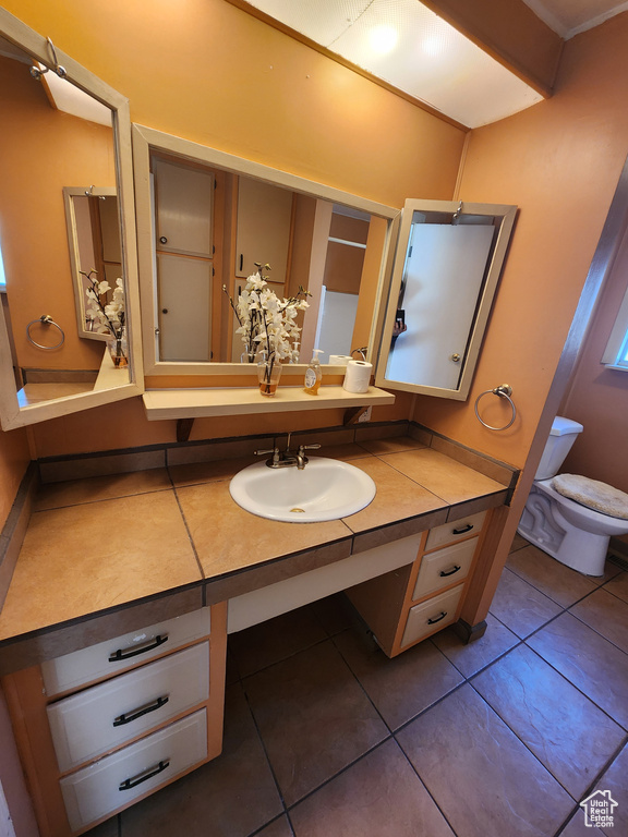 Bathroom with toilet, tile patterned flooring, and vanity