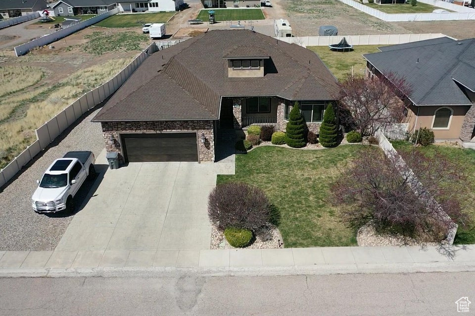 View of front of house with a garage, cooling unit, fence, brick siding, and driveway