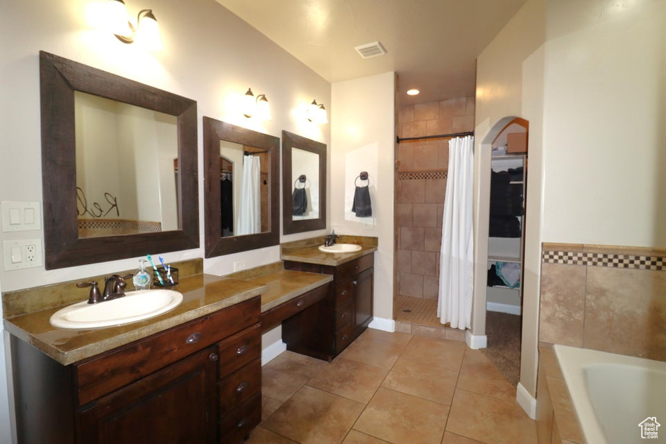 Bathroom featuring a garden tub, a tile shower, tile patterned floors, visible vents, and vanity