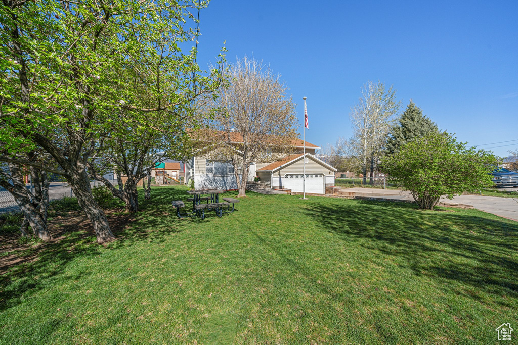 View of front of property with a front yard and a garage