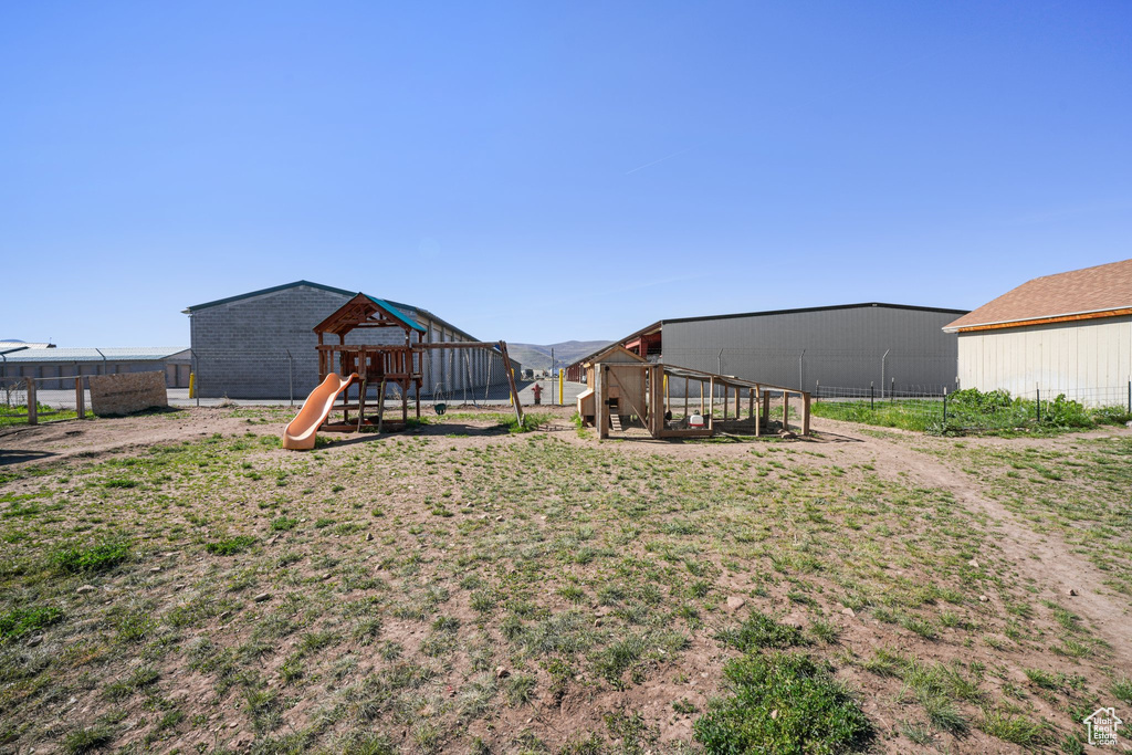 View of yard with a playground, an outbuilding, exterior structure, and fence