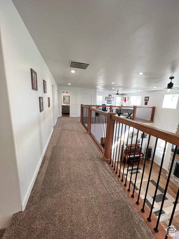Hall with baseboards, recessed lighting, and visible vents