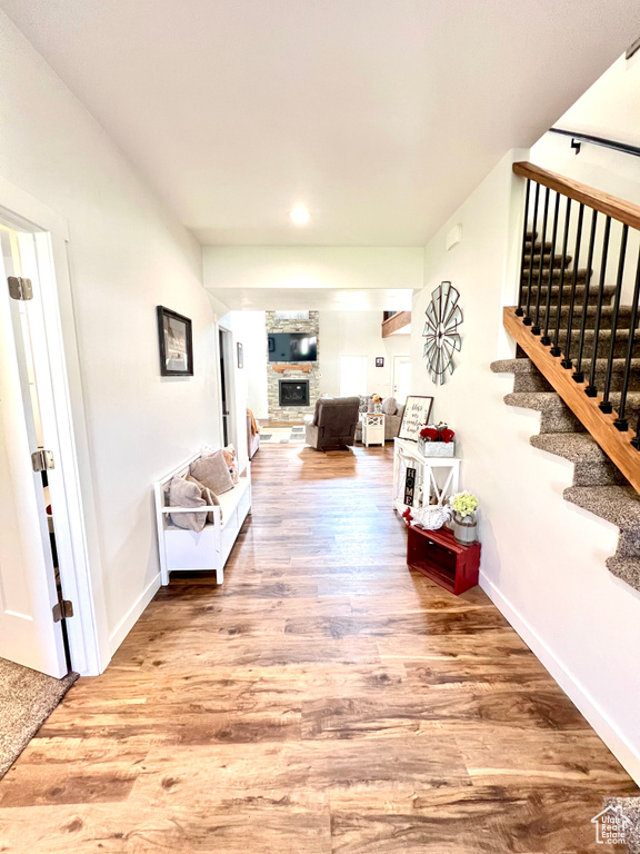 Hall with baseboards, stairs, and wood finished floors