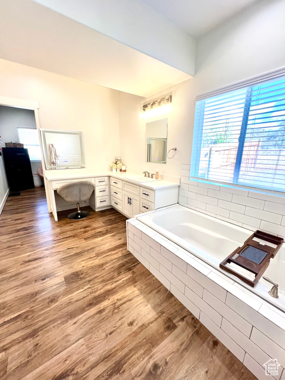 Full bathroom featuring a bath, wood finished floors, and vanity
