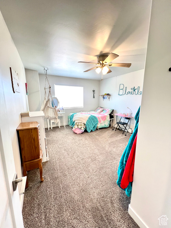 Carpeted bedroom featuring ceiling fan