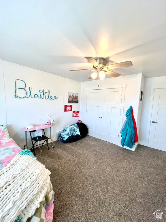 Carpeted bedroom with a ceiling fan and a closet