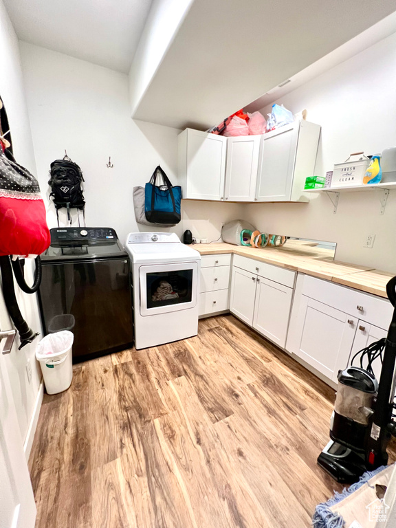 Kitchen with light wood finished floors, separate washer and dryer, open shelves, white cabinets, and butcher block countertops