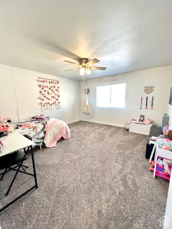 Game room with a ceiling fan, baseboards, and carpet