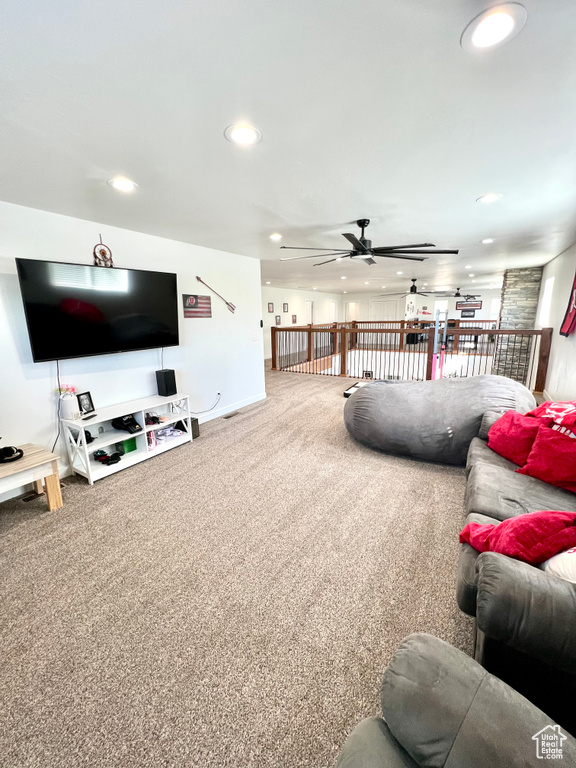 Carpeted living area with ceiling fan and recessed lighting