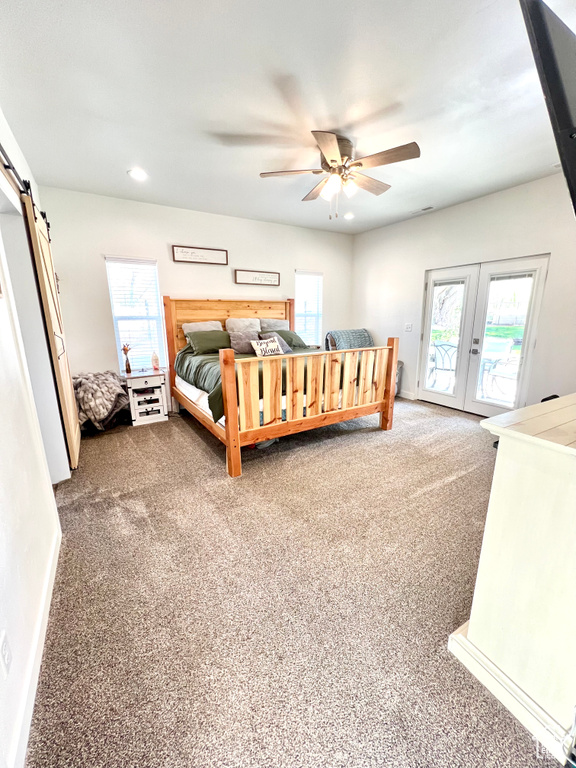 Carpeted bedroom featuring a ceiling fan, french doors, recessed lighting, a barn door, and access to outside