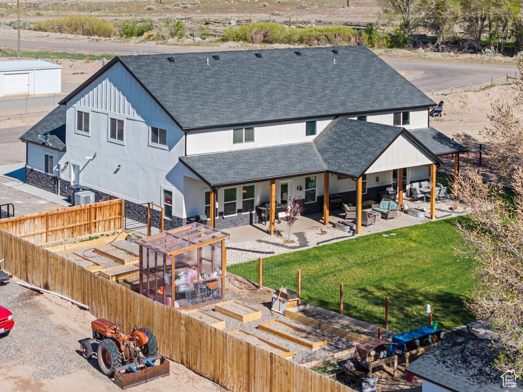 Back of house with a shingled roof, outdoor lounge area, a patio, and a fenced backyard