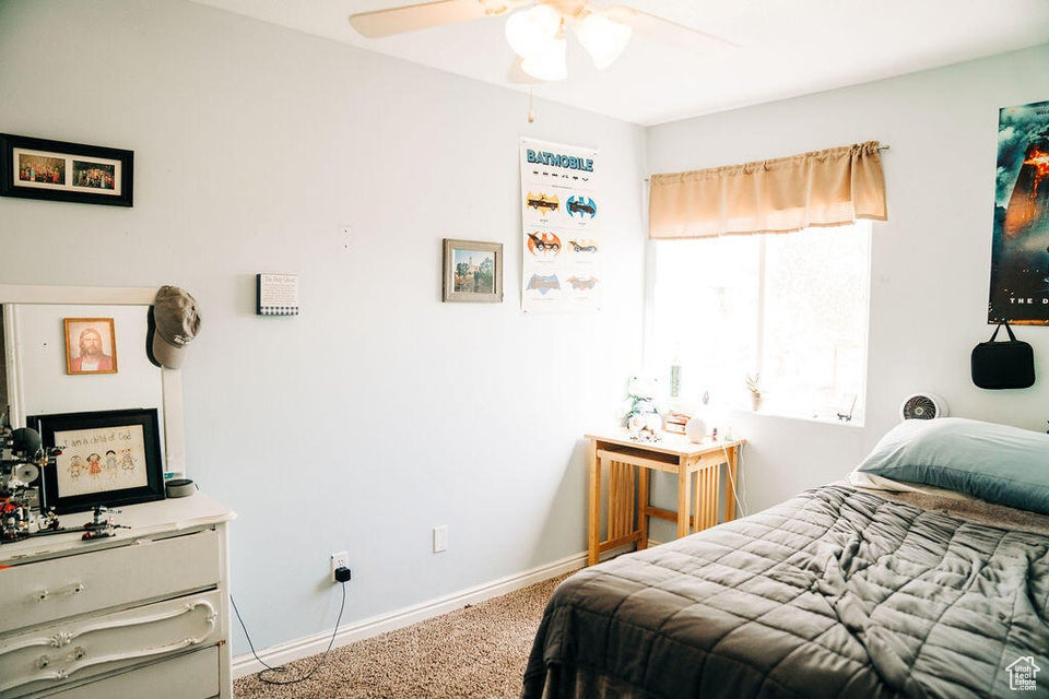Bedroom featuring baseboards, carpet flooring, and a ceiling fan