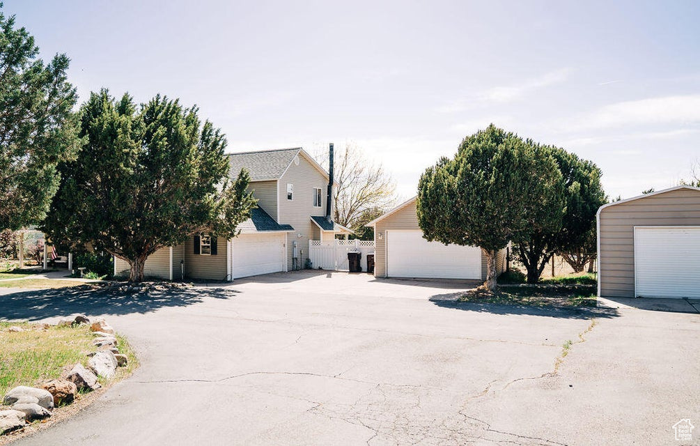 View of home's exterior featuring an outbuilding, fence, and a garage