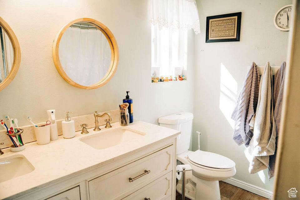 Full bathroom featuring a wealth of natural light, toilet, and a sink
