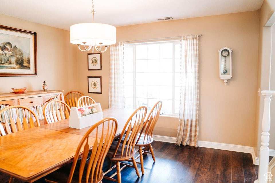 Dining space with dark wood-style flooring, a wealth of natural light, baseboards, and visible vents
