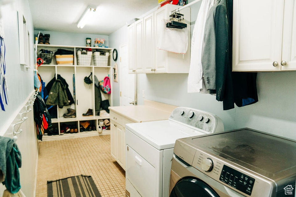 Laundry room featuring cabinet space, washing machine and clothes dryer, and light tile patterned floors