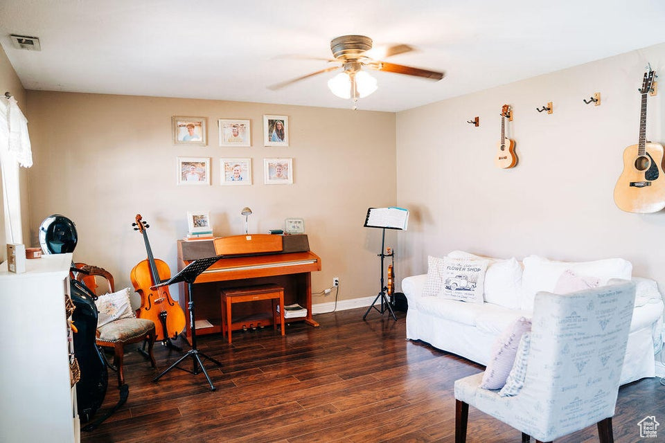 Sitting room with visible vents, wood finished floors, baseboards, and ceiling fan