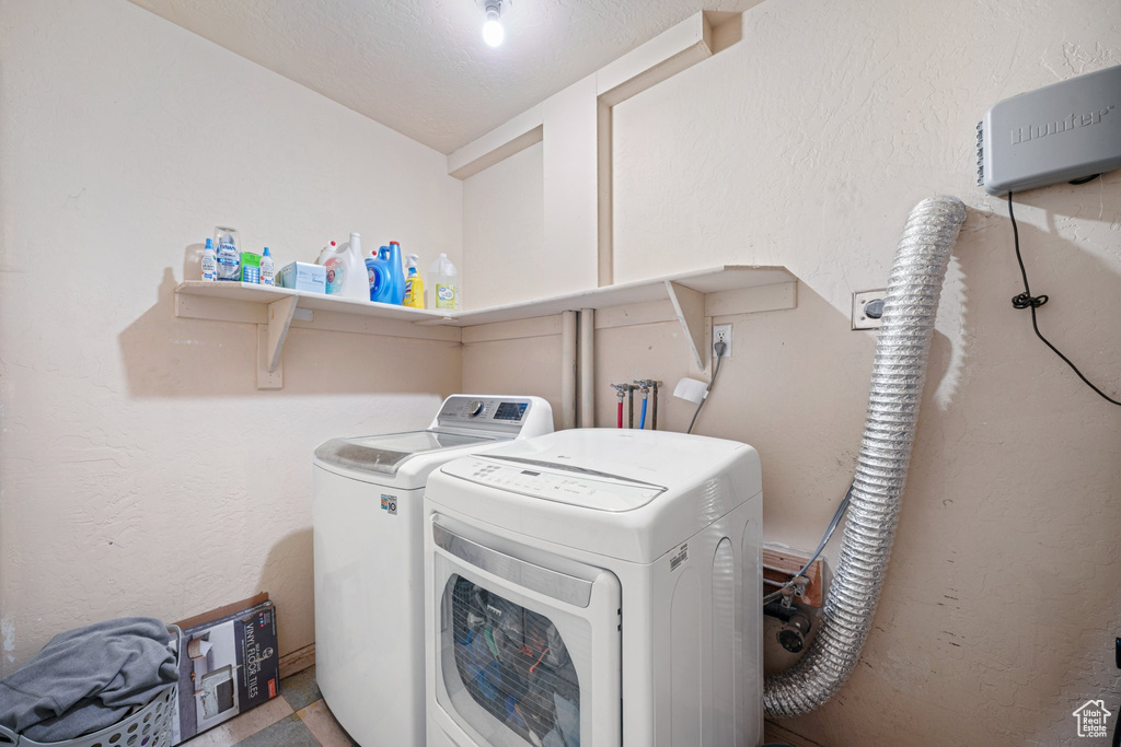 Washroom featuring separate washer and dryer and laundry area