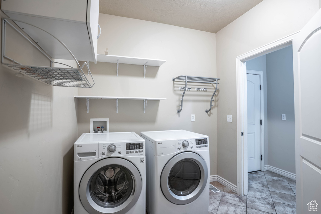 Laundry area featuring washer and dryer, laundry area, and baseboards