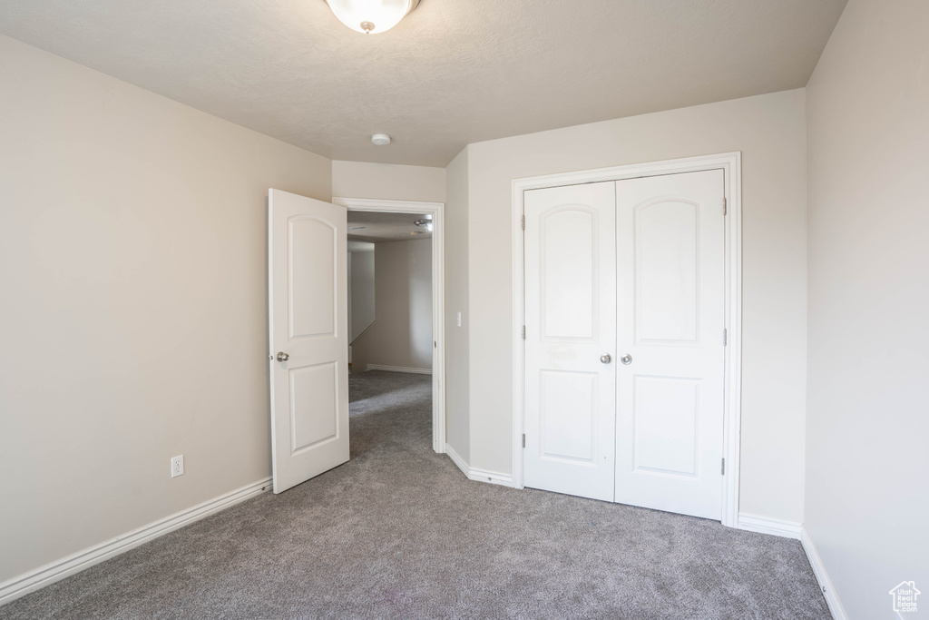 Unfurnished bedroom with baseboards, a closet, and carpet floors