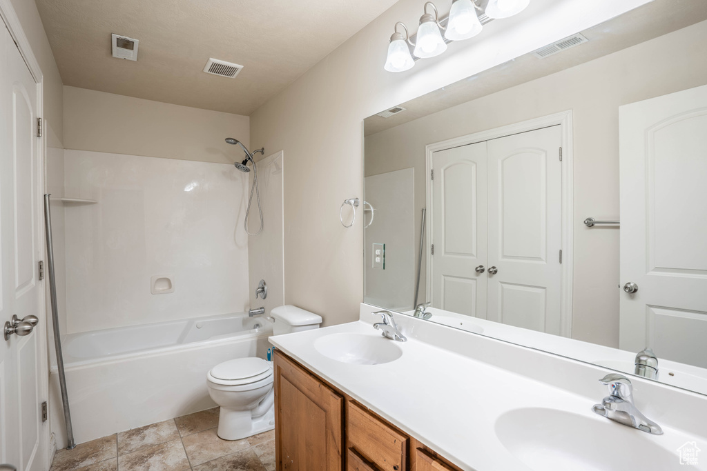 Full bath with a sink, toilet, shower / bathtub combination, and visible vents