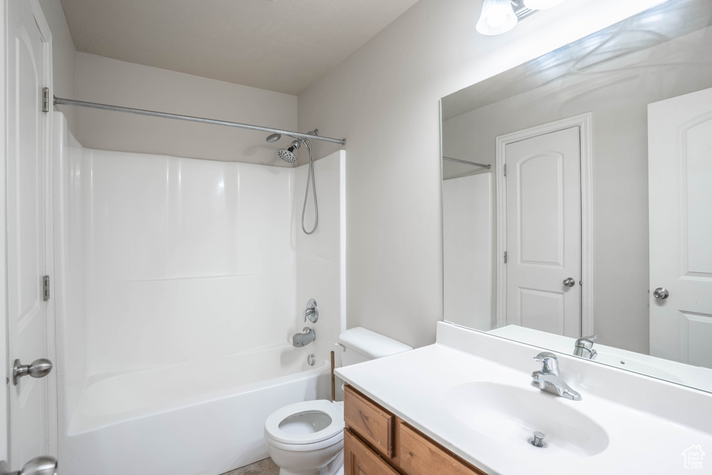 Bathroom featuring shower / bathing tub combination, vanity, and toilet