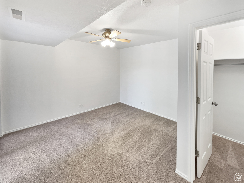 Interior space with baseboards, visible vents, ceiling fan, and carpet floors