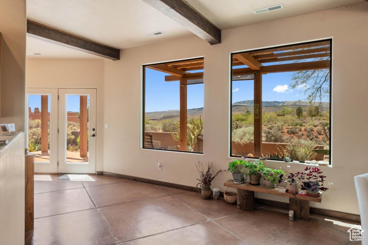 Doorway featuring a mountain view, beam ceiling, visible vents, and a healthy amount of sunlight