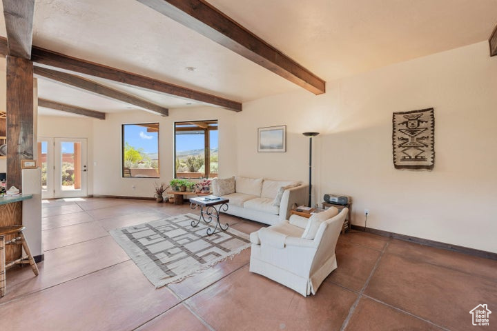 Living area featuring beam ceiling and baseboards