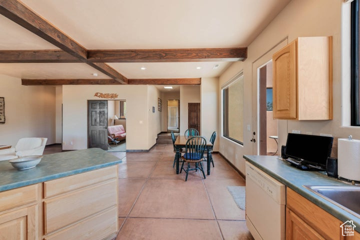 Kitchen featuring dishwasher, beam ceiling, plenty of natural light, and light brown cabinets