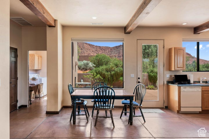 Dining space with finished concrete flooring, beamed ceiling, and visible vents