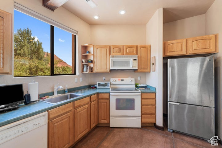 Kitchen featuring a sink, white appliances, a toaster, recessed lighting, and light brown cabinetry
