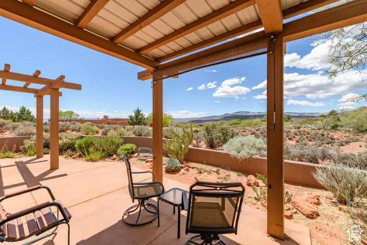 View of patio with a pergola, fence, and a mountain view