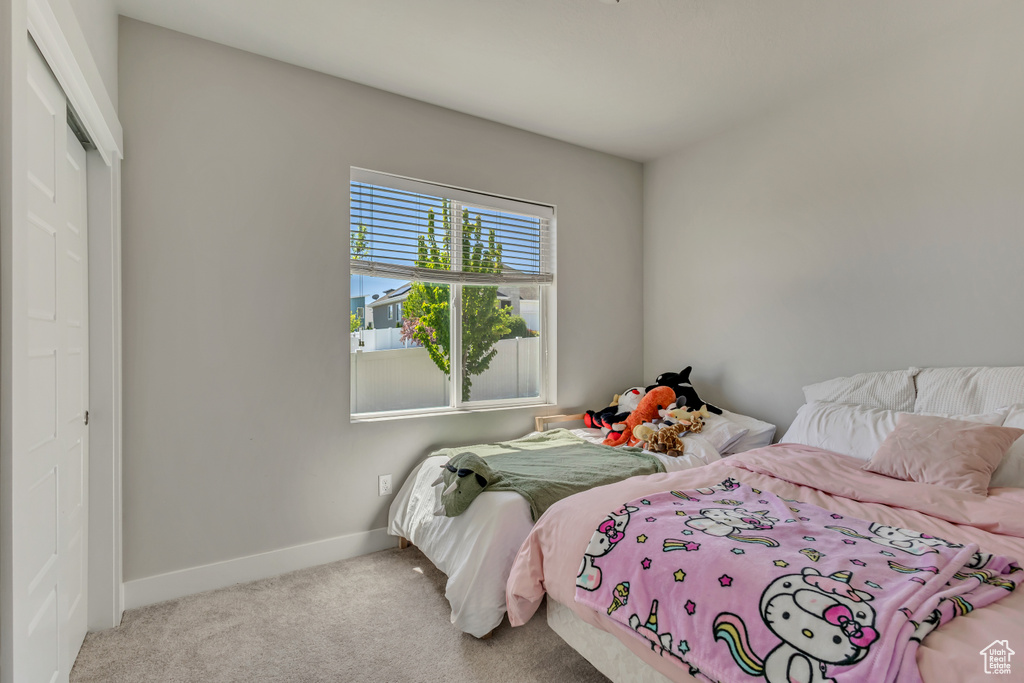 Bedroom featuring carpet, baseboards, and a closet