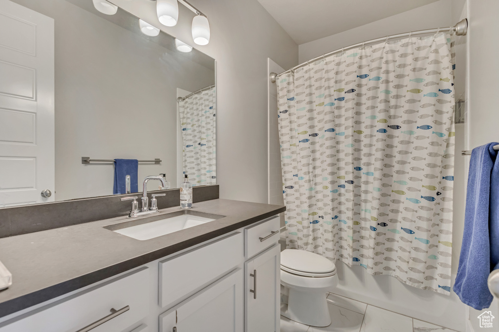 Bathroom with shower / bath combination with curtain, toilet, and vanity