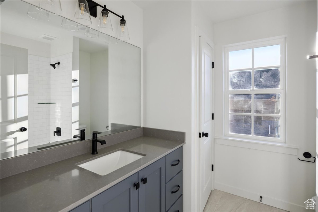 Bathroom with vanity, a shower, toilet, baseboards, and tile patterned floors