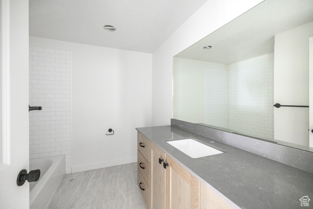 Full bath with baseboards and vanity