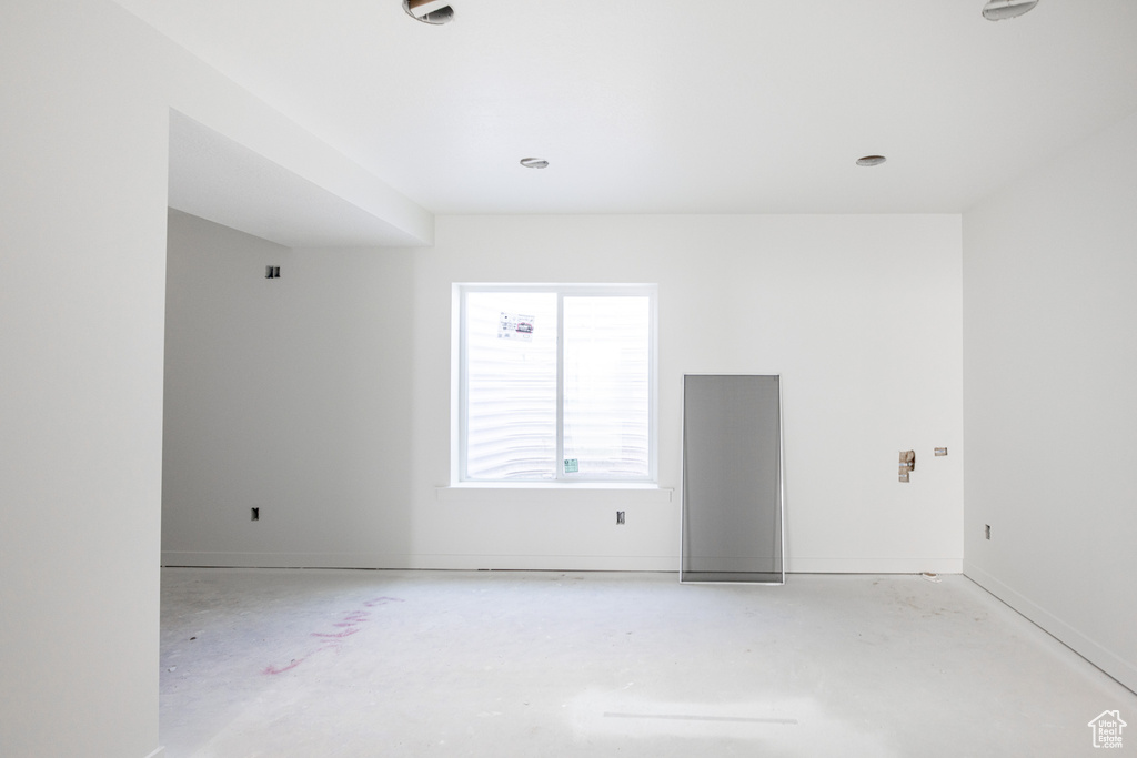 Empty room with concrete flooring and baseboards