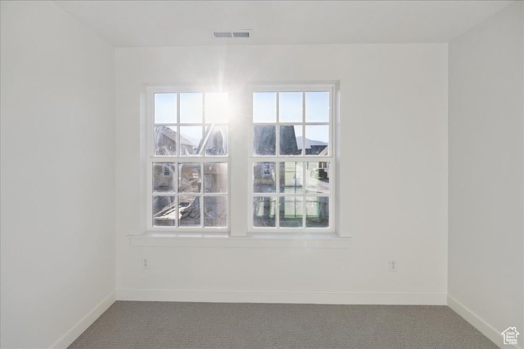 Carpeted empty room with baseboards